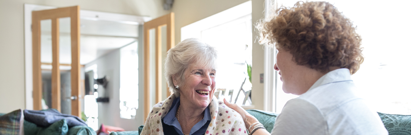 living with dementia_carer laughing with elderly