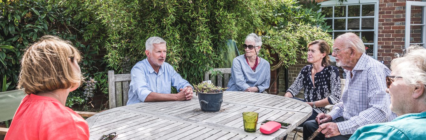 carers and patients sat around a table together outside