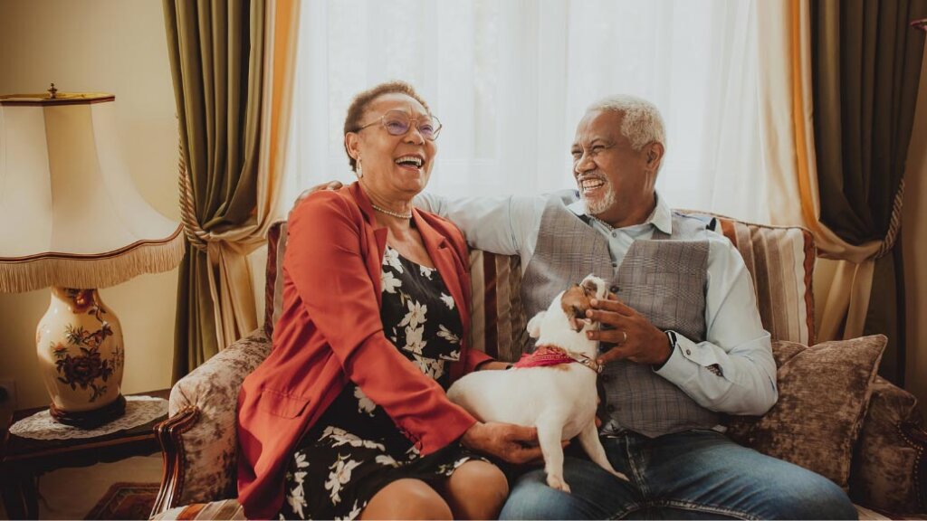 Man and woman laughing in living room with dog